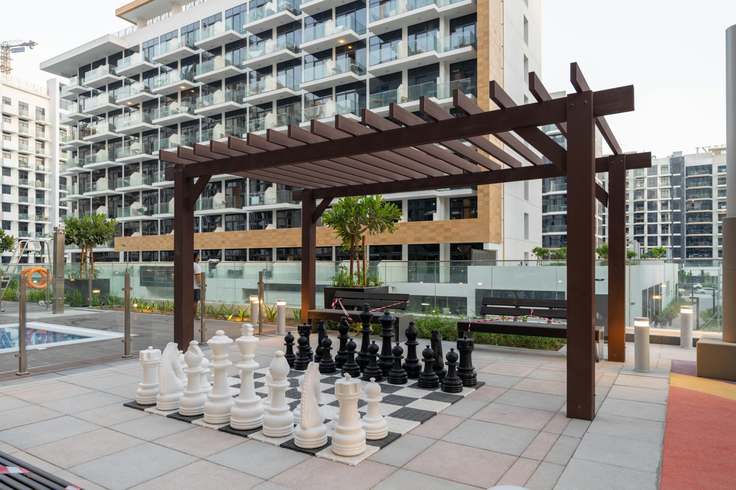 Large chess set on a modern terrace in Dubai surrounded by contemporary architecture.